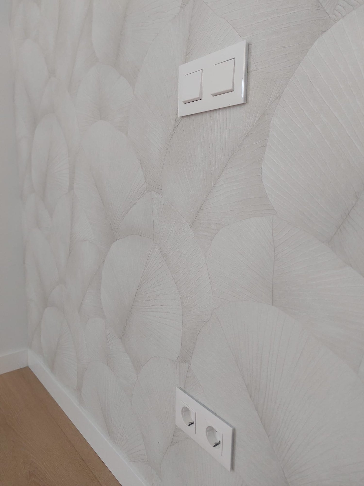Detalle de papel pintado blanco con relieve de hojas