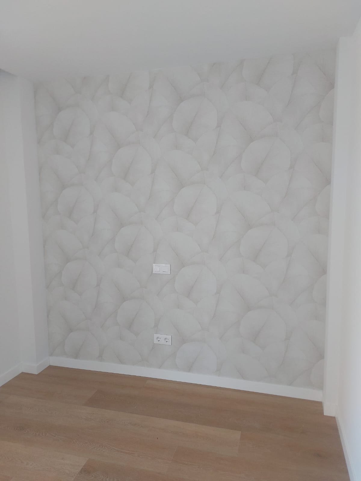 Dormitorio con papel pintado blanco de relieve floral en toda la pared