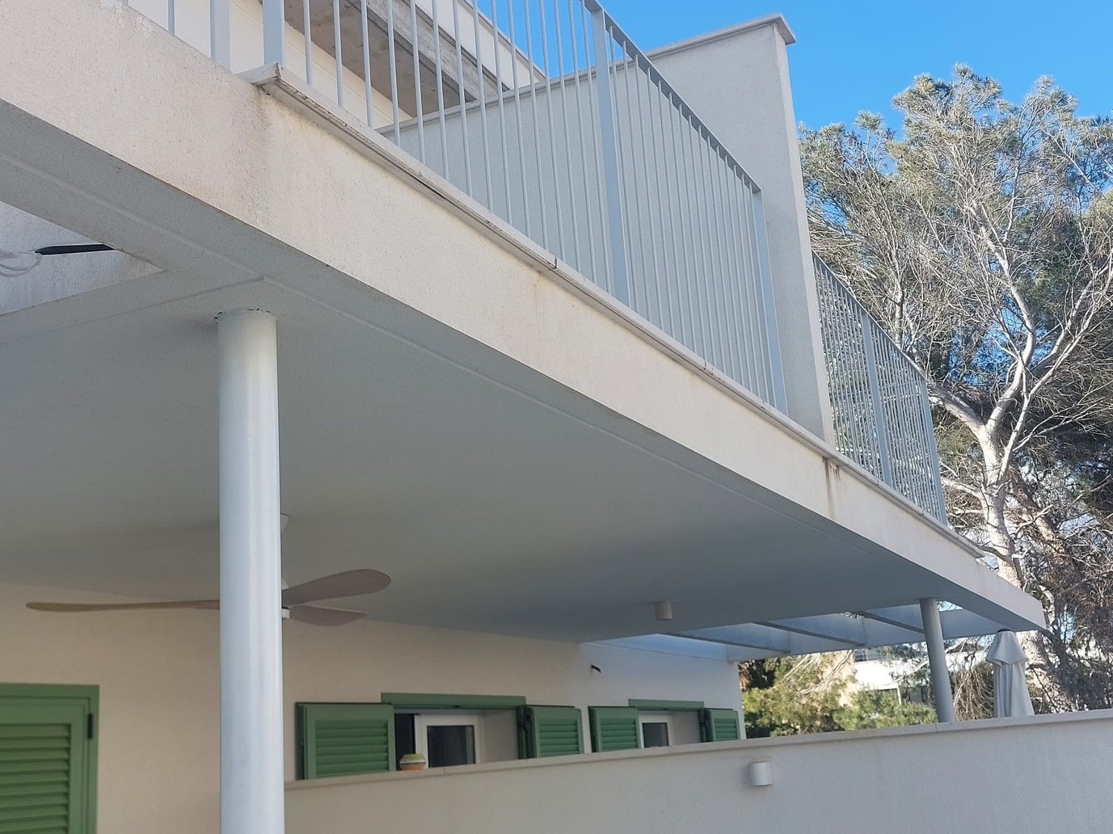 Porche exterior de una vivienda con las paredes pintadas en blanco