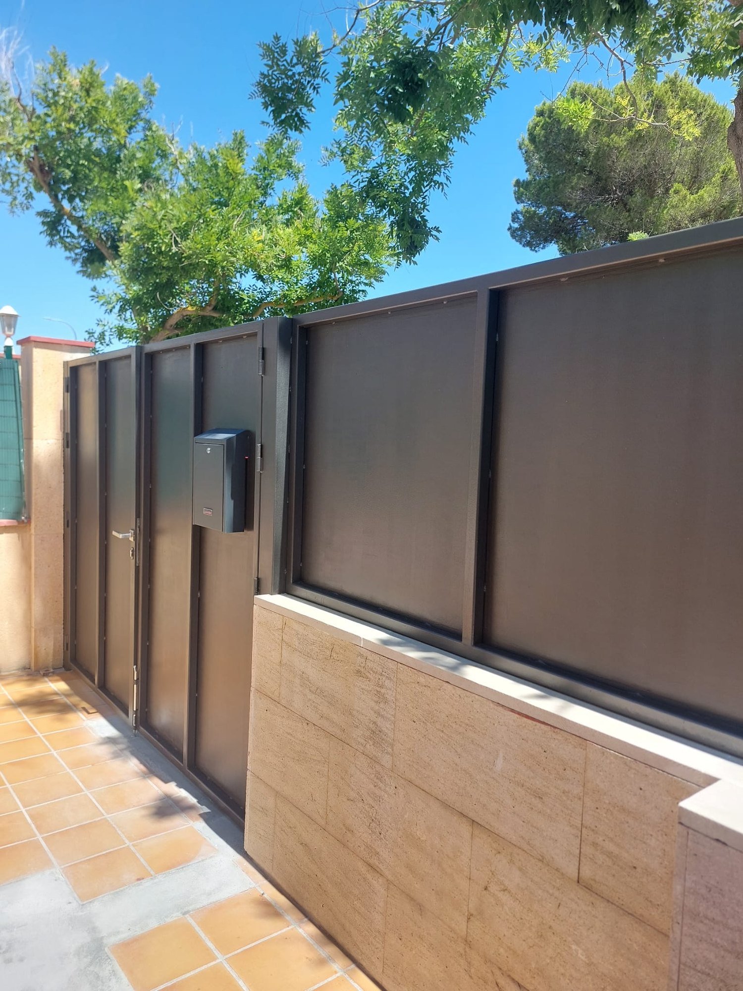Portón metálico pintado en el acceso exterior a una vivienda