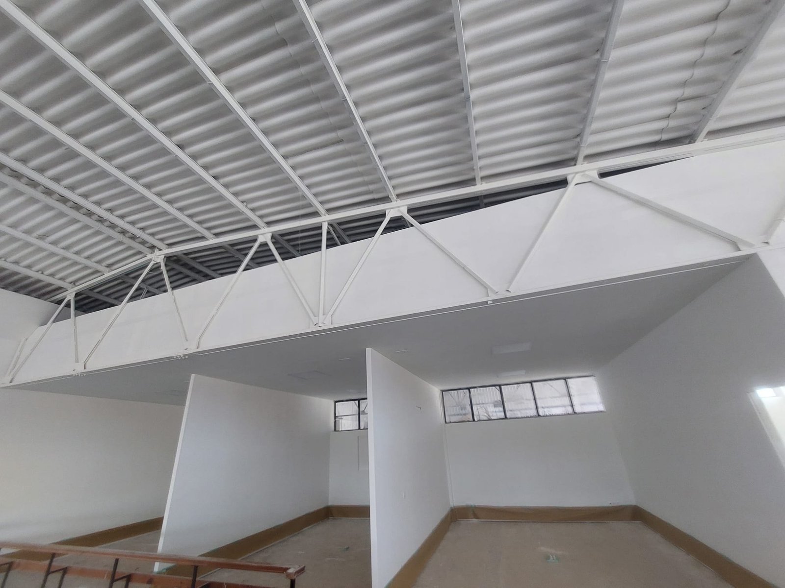 Interior de nave industrial con paredes y estructura metálica pintadas en blanco